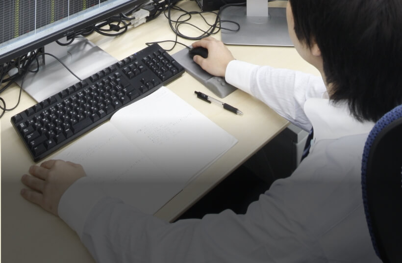 紙とマウスで作業する手元