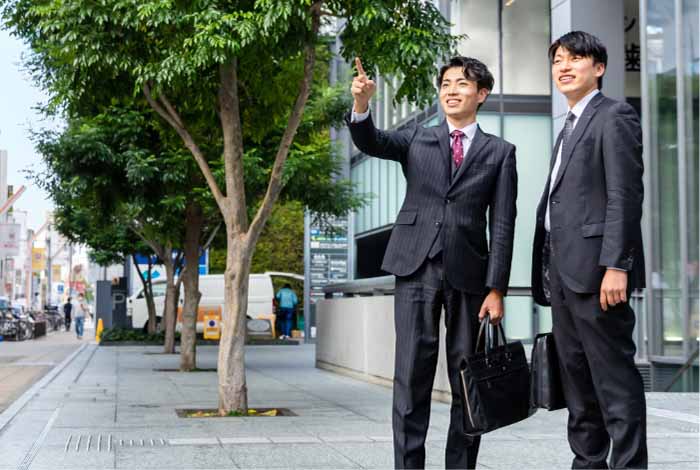 行き先を指さす男性とそれを見つめるもう一人の男性