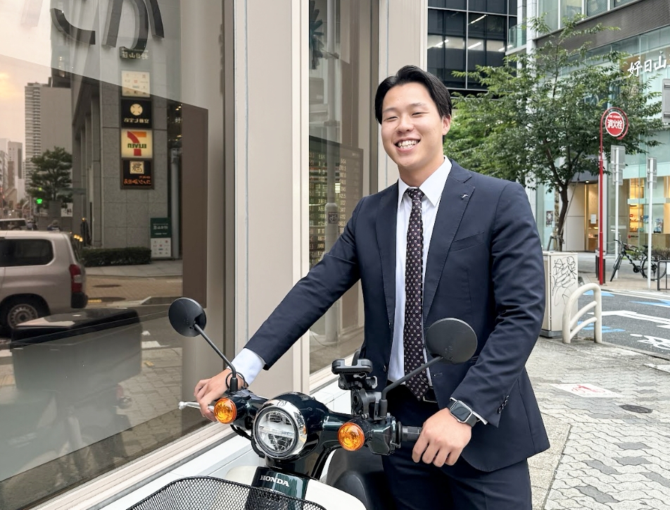 バイクを押しているスーツ姿の営業職男性社員