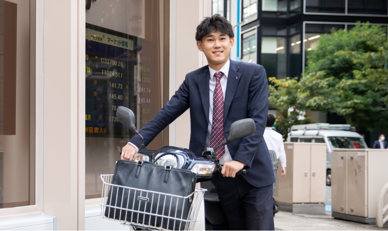 バイクを押して歩いている男性営業社員